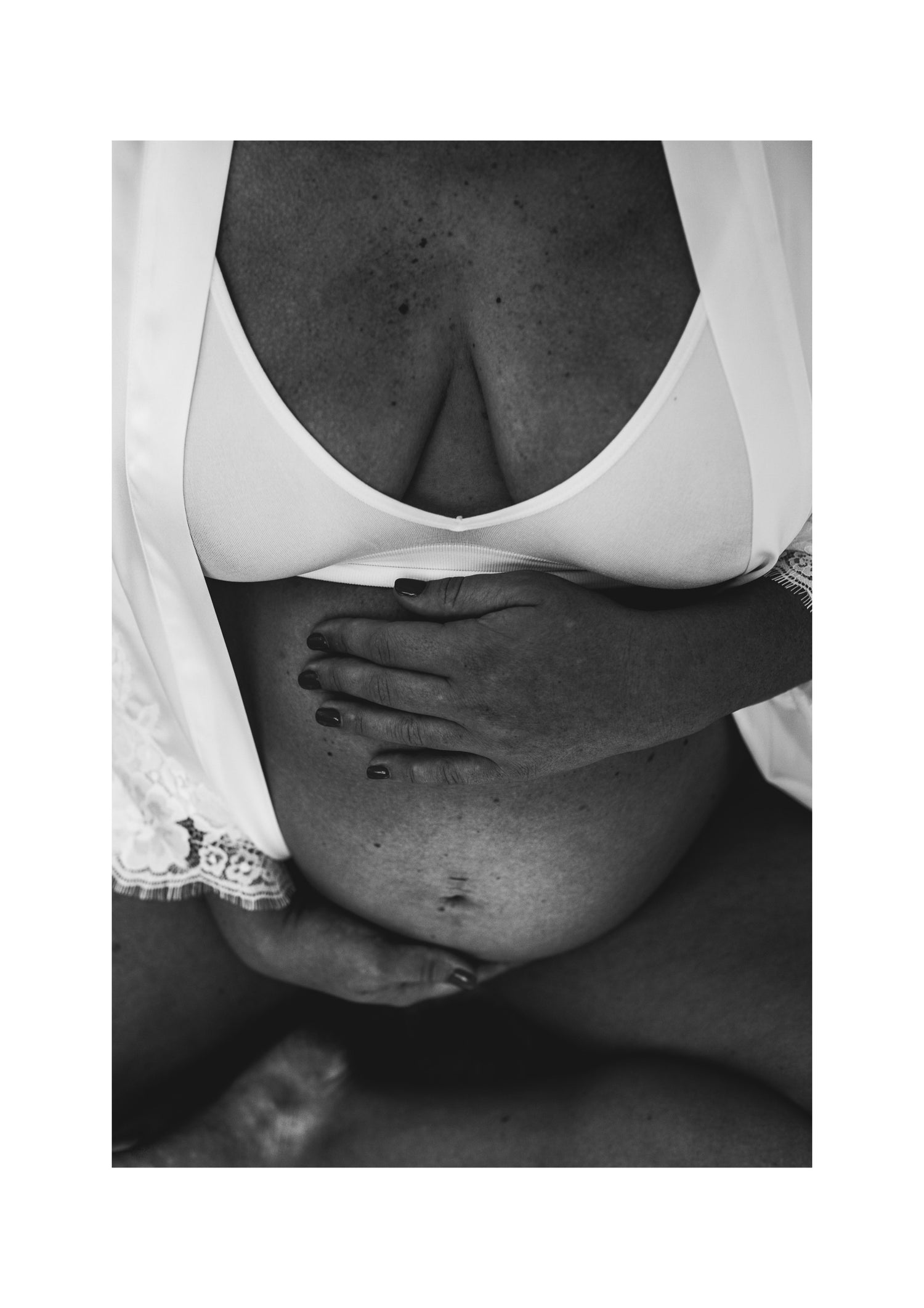 Full term pregnancy photo of women baby in belly. Hands wrapped around the belly feeling the baby's movement. 